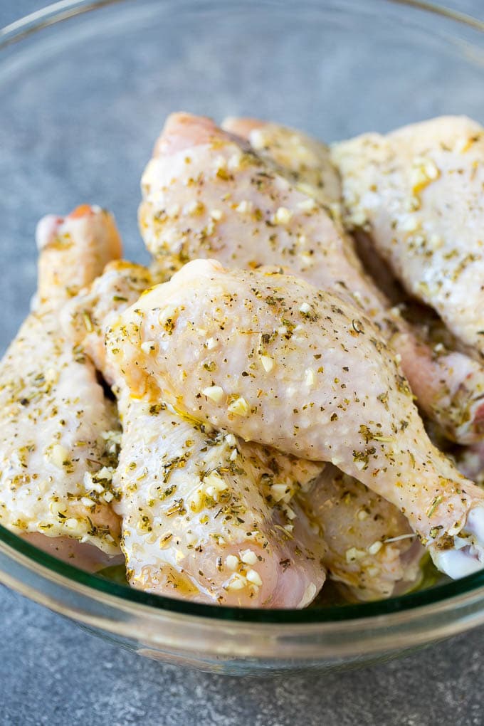 Baked Chicken Drumsticks Recipe | Roasted Chicken Drumsticks | Garlic and Herb Chicken #dinner #chicken #garlic #glutenfree #lowcarb #keto #cleaneating #bajap A bowl of chicken legs in a garlic and herb marinade.