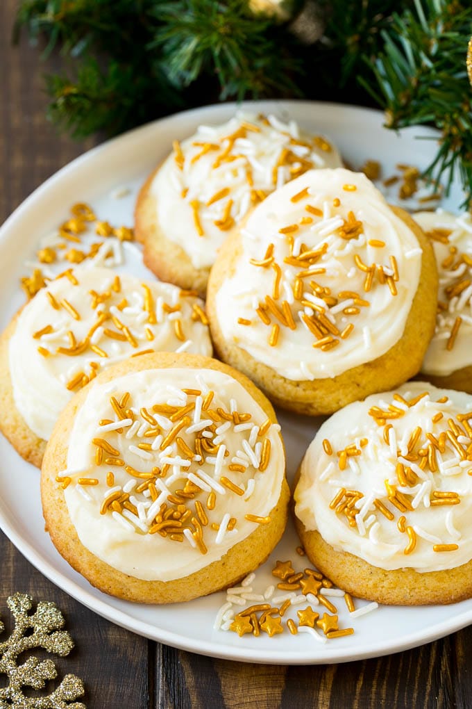 Eggnog Cookies Recipe | Holiday Cookies | Christmas Cookies #cookies #eggnog #baking #christmas #sprinkles #dessert #bajap Eggnog cookies topped with frosting and gold sprinkles on a serving plate.