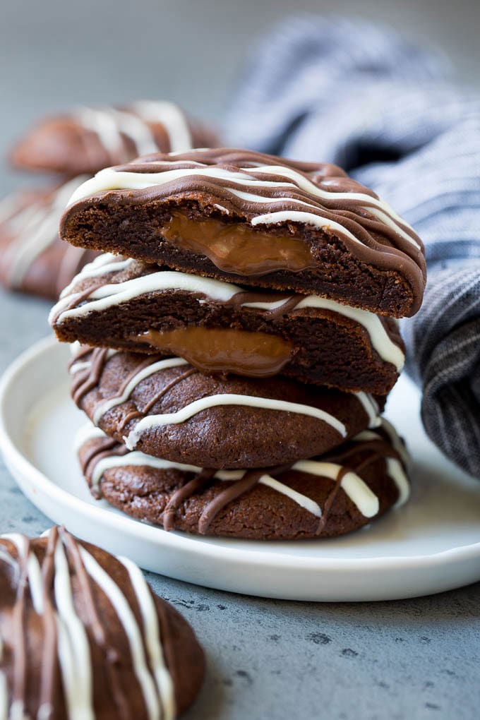Nutella Cookies Recipe | Nutella Stuffed Cookies | Chocolate Cookies #nutella #chocolate #cookies #baking #dessert #bajap A stack of Nutella cookies on a plate with one cut open.