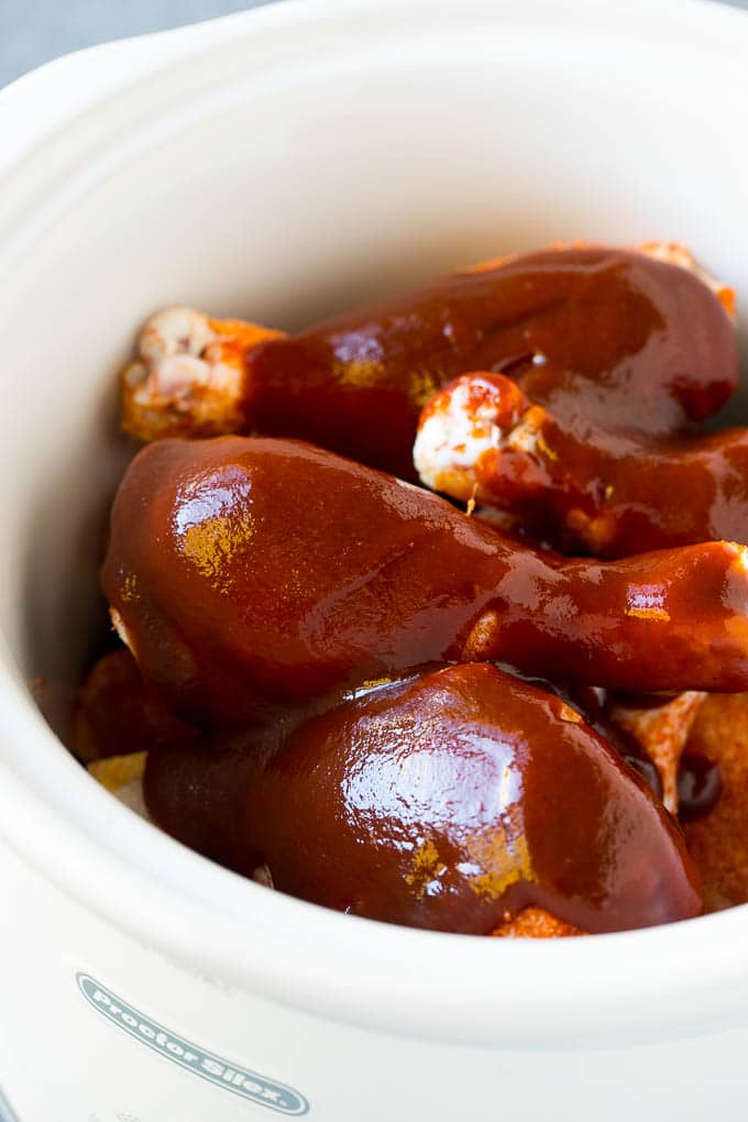 Slow Cooker Chicken Drumsticks Recipe | Crock Pot Chicken Drumsticks | BBQ Chicken Drumsticks #chicken #drumsticks #slowcooker #crockpot #bbq #dinner #bajap A crock pot of chicken drumsticks coated in BBQ sauce.