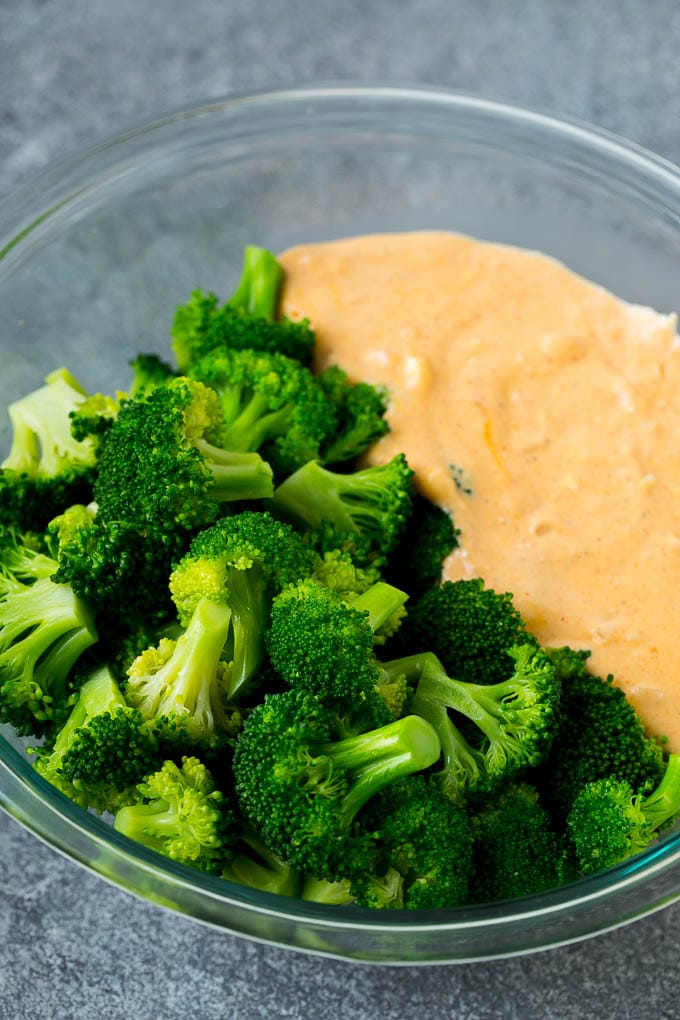 Cooked florets and cheese sauce in a mixing bowl.