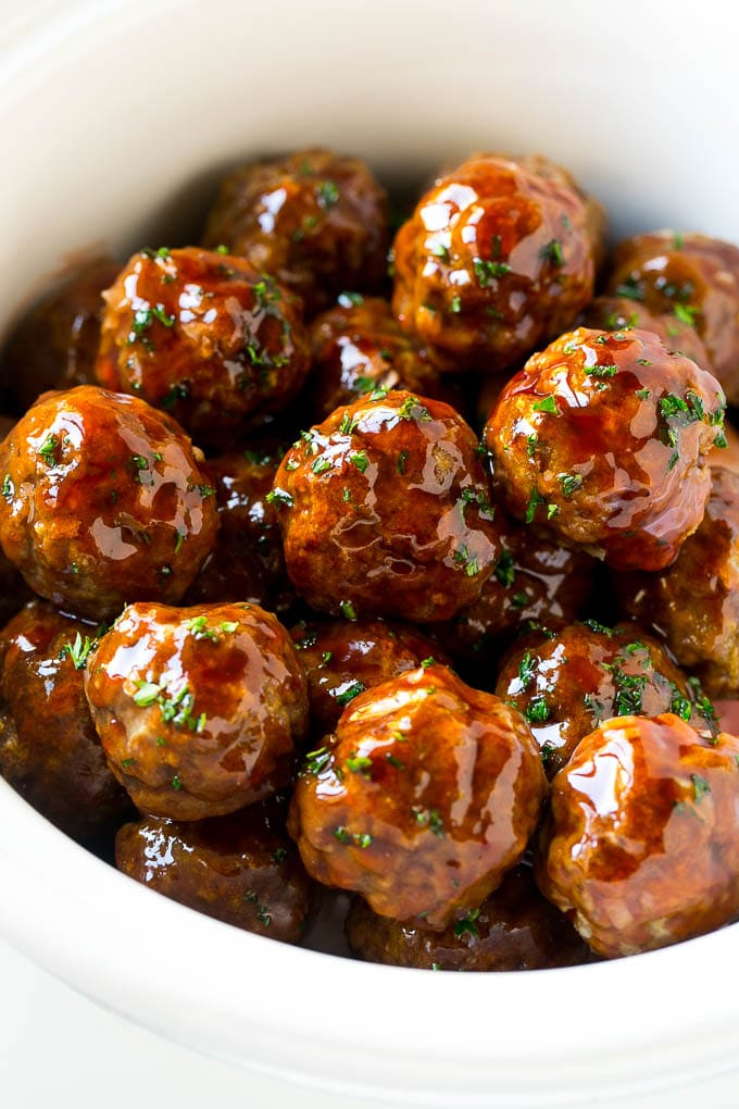Sweet and Sour Meatballs Recipe | Slow Cooker Meatballs | Crockpot Meatballs | Cocktail Meatballs #meatballs #beef #slowcooker #crockpot #dinner #appetizer #bajap Sweet and sour meatballs garnished with parsley in a slow cooker.