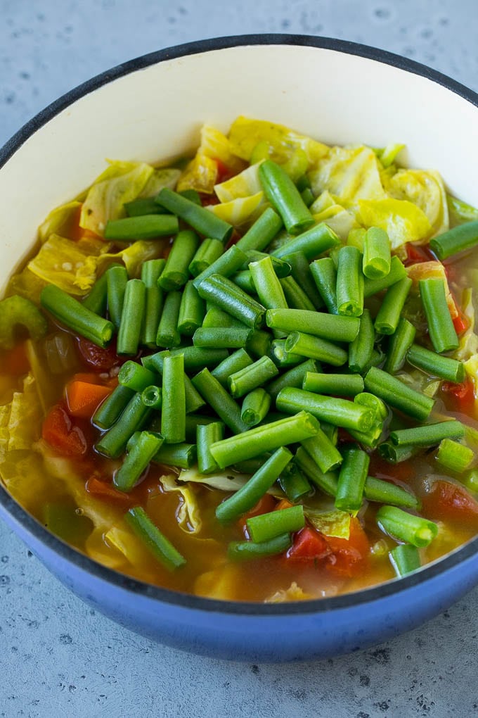 Cabbage Soup Recipe | Vegetable Soup | Veggie Soup | Healthy Soup #soup #healthy #cleaneating #cabbage #vegetables #veggies #dinner #bajap Green beans in a pot of cooked veggies.