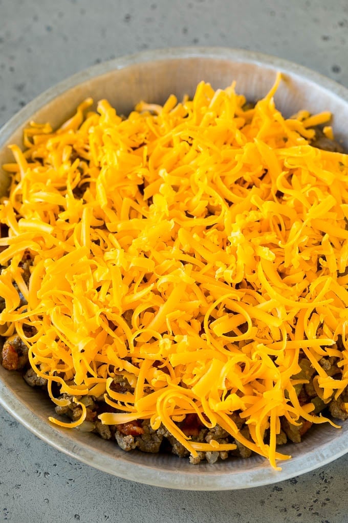 Cheeseburger Pie Recipe | Cheeseburger Casserole | Ground Beef Recipe #cheeseburger #beef #bacon #cheese #casserole #dinner #bajap Ground beef and shredded cheddar cheese in a dish.