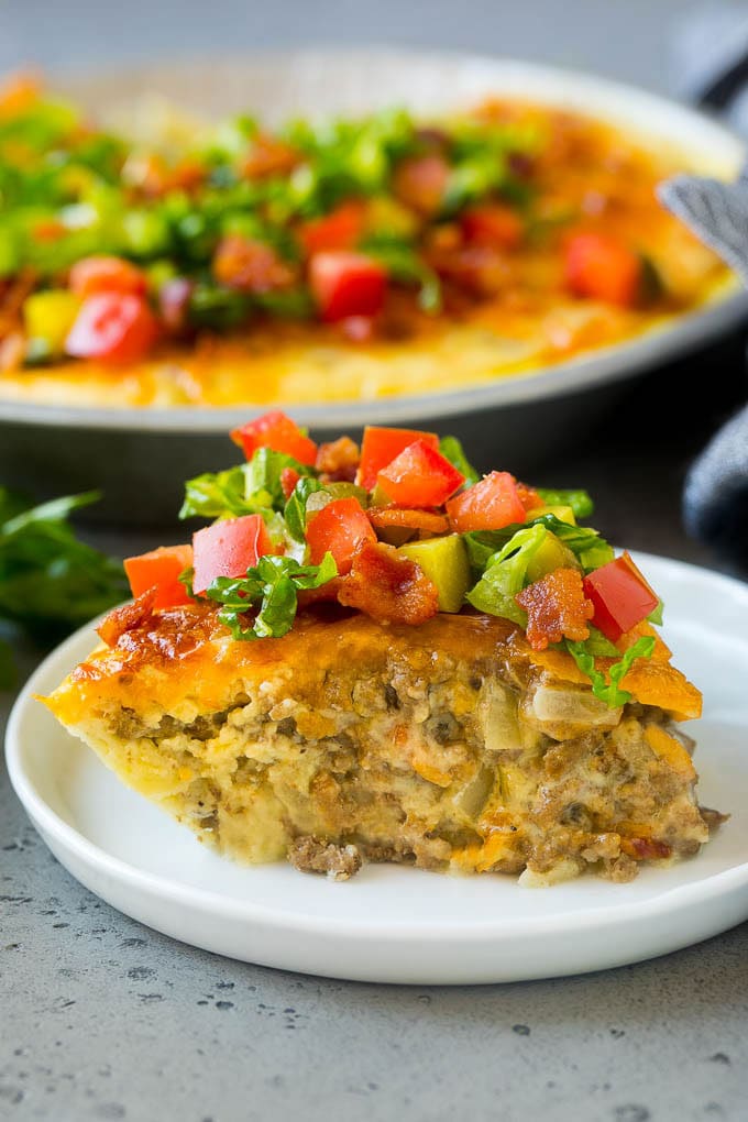 Cheeseburger Pie Recipe | Cheeseburger Casserole | Ground Beef Recipe #cheeseburger #beef #bacon #cheese #casserole #dinner #bajap A slice of cheeseburger pie garnished with shredded lettuce, diced tomatoes and pickles.