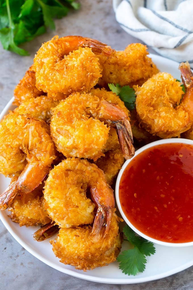 Coconut Shrimp Recipe | Fried Shrimp | Shrimp Appetizer #shrimp #coconut #appetizer #seafood #dinner #bajap A plate of coconut shrimp with a bowl of sweet chili sauce.