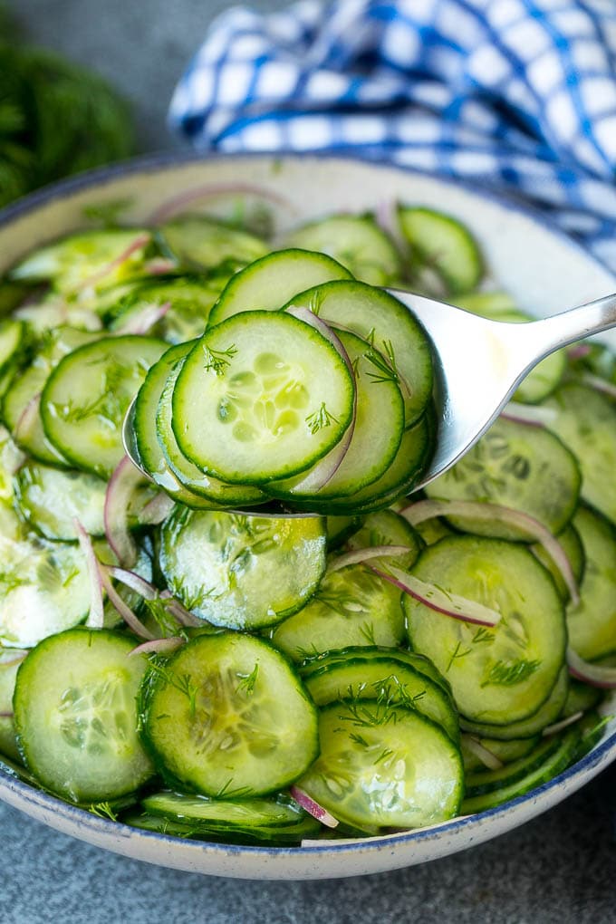 Cucumber Salad Recipe | Cucumber Dill Salad | Cucumber Recipe #cucumbers #salad #glutenfree #sidedish #bajap A spoon serving up a portion of classic cucumber salad.