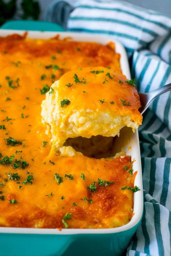Hash Brown Casserole | Potato Casserole | Hash Brown Side Dish #potatoes #cheese #casserole #sidedish #bajap A spatula pulling out a serving of cheesy hash brown casserole.
