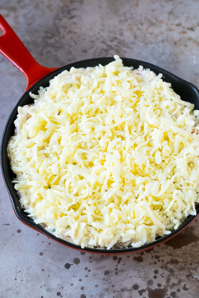 Reuben Dip Recipe | Corned Beef Dip | Cheese Dip #dip #cheese #cornedbeef #appetizer #lowcarb #keto #bajap A skillet of dip topped with shredded cheese.