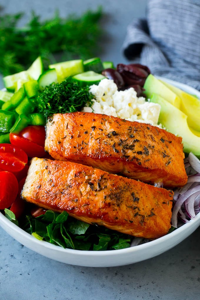Greek Salmon Salad Recipe | Low Carb Salmon Recipe | Salmon Salad #salmon #seafood #fish #lowcarb #keto #lunch #bajap #healthy Salmon fillets on lettuce with tomatoes, feta cheese, avocado, olives, cucumbers and herbs.