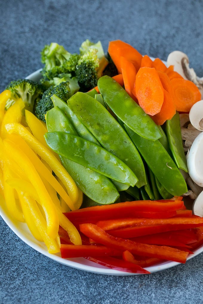 Vegetable Stir Fry Recipe | Veggie Stir Fry | Broccoli Stir Fry #vegetarian #vegetables #broccoli #dinner #bajap Bell peppers, snow peas, carrots, mushrooms and broccoli on a plate.