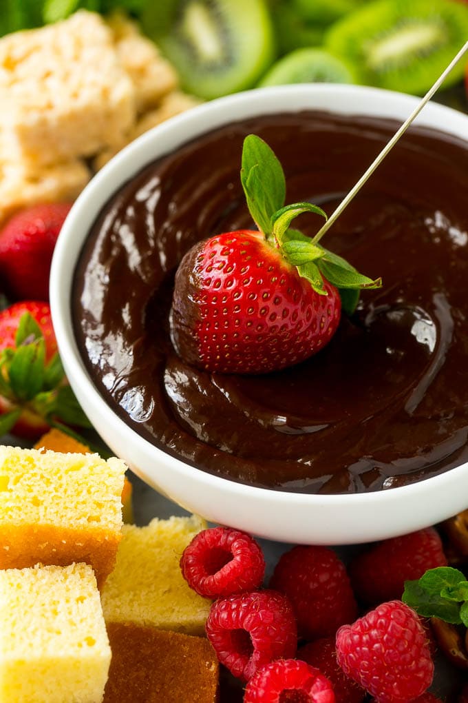 Chocolate Fondue Recipe | Chocolate Sauce | Chocolate Dip #chocolate #dessert #glutenfree #fondue #bajap A strawberry being dipped into a bowl of fondue.