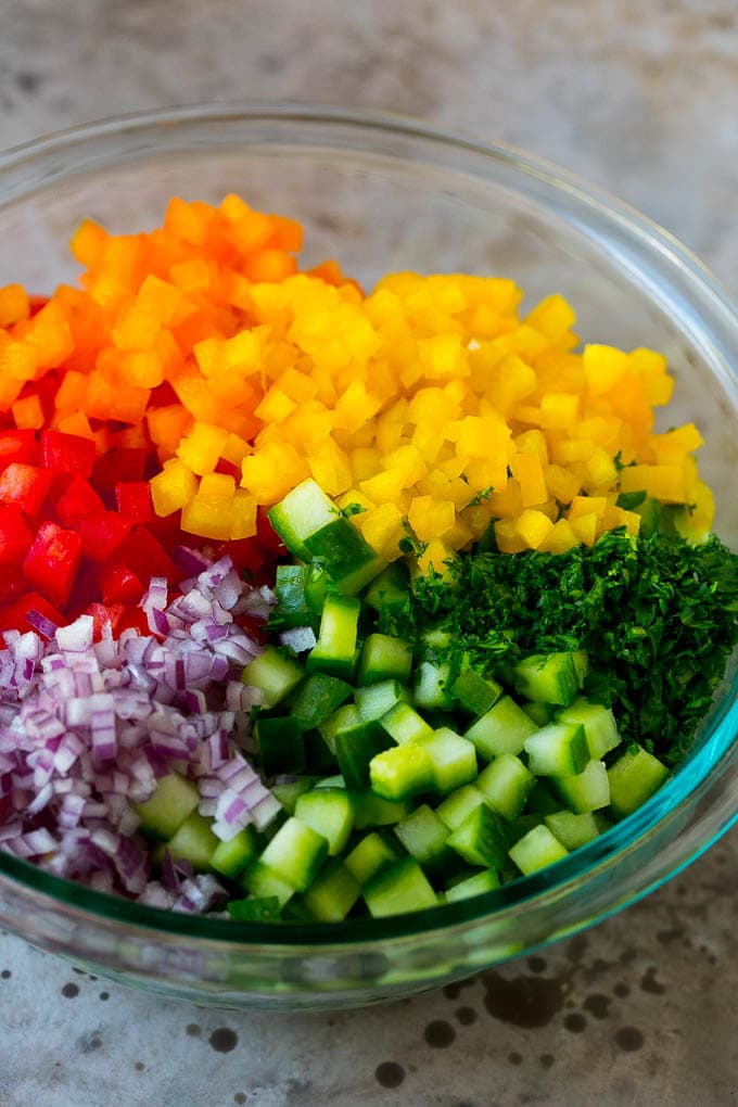 Israeli Salad Recipe | Cucumber Salad | Tomato Salad | Chopped Salad #salad #cleaneating #healthy #glutenfree #lowcarb #keto #sidedish #lunch #bajap Chopped peppers, cucumbers, tomatoes and onions in a bowl.