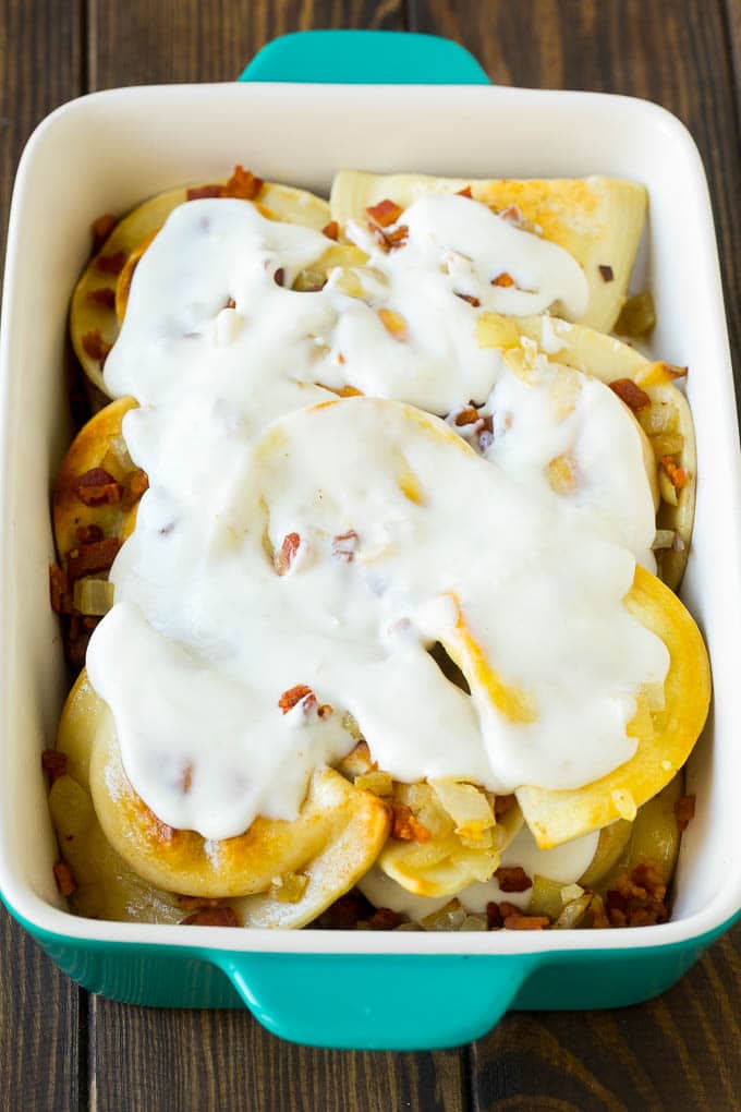 Pierogi Casserole Recipe | Potato Casserole #pierogis #casserole #bacon #cheddar #dinner #bajap Dumplings in a baking dish covered with creamy sauce.