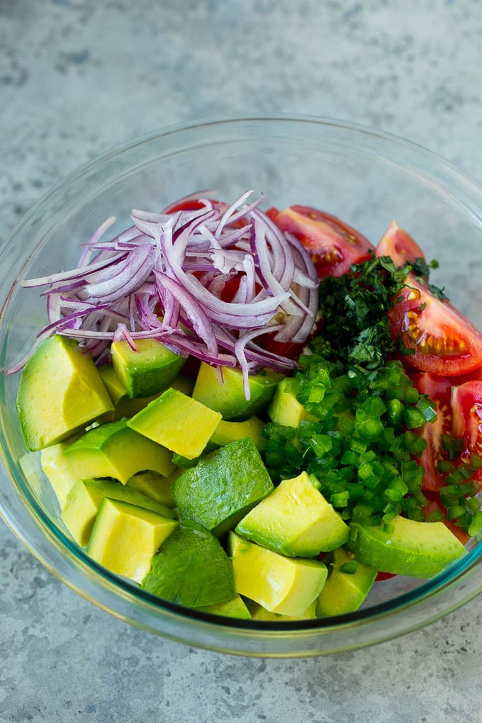 Tomato Avocado Salad Recipe | Avocado Salad | Tomato Salad #salad #tomato #avocado #glutenfree #cleaneating #dinner #bajap #healthy Pieces of avocado, tomato, red onion and minced jalapeno in a salad bowl.