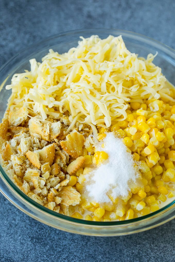 Scalloped Corn | Corn Casserole #corn #casserole #cheese #sidedish #dinner #bajap Corn, crushed crackers, seasonings and shredded cheese in a bowl.