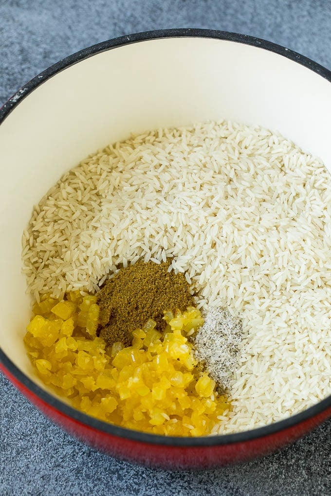 Black Beans and Rice Recipe | Cuban Black Beans | Beans and Rice #beans #rice #blackbeans #sidedish #glutenfree #dinner #bajap Onions, garlic, white rice and spices in a pot.