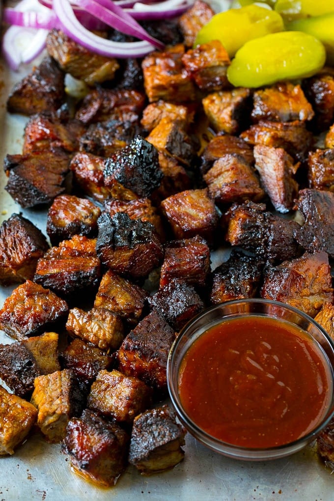 Burnt Ends Recipe | Smoked Brisket | Beef Brisket #brisket #bbq #smoker #beef #dinner #bajap Burnt ends on a sheet pan served with BBQ sauce, red onions and pickles.