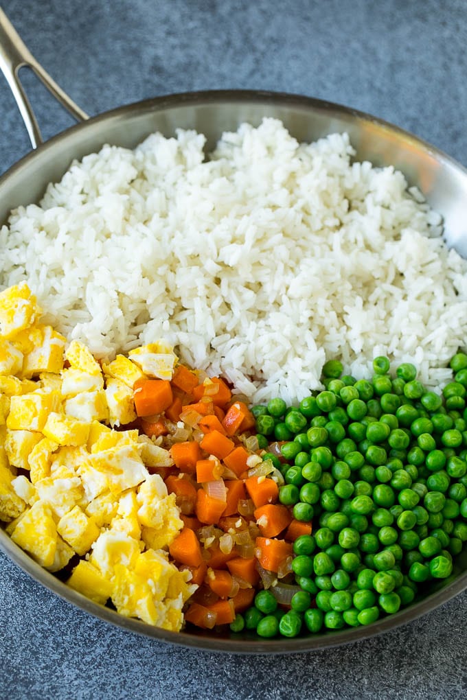 Chicken Fried Rice Recipe | Chinese Fried Rice #rice #chicken #peas #carrots #sidedish #dinner #bajap A pan of cooked rice, carrots, eggs and peas.