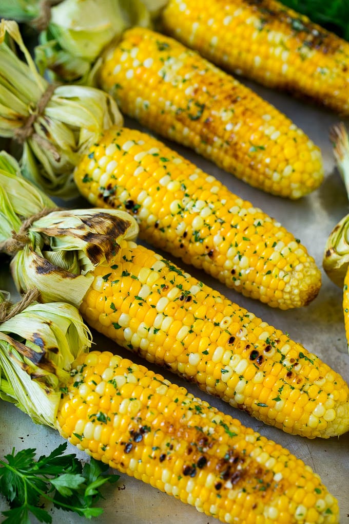 Grilled Corn on the Cob Recipe | Corn Recipe #corn #grilling #summer #sidedish #dinner #bajap Grilled corn on the cob topped with garlic and herb butter on a sheet pan.