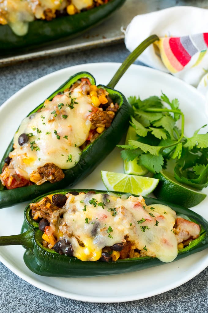 Stuffed Poblano Peppers | Stuffed Peppers | Pasilla Peppers #peppers #stuffedpeppers #beef #rice #beans #corn #dinner #bajap A plate of stuffed poblano peppers topped with melted cheese.