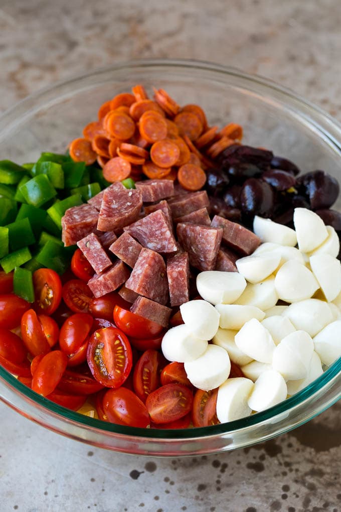 Italian Pasta Salad | Pasta Salad Recipe #pasta #salad #pastasalad #pepperoni #salami #olives #cheese #sidedish #bajap A bowl of pasta, mozzarella balls, cherry tomatoes, bell peppers and olives.