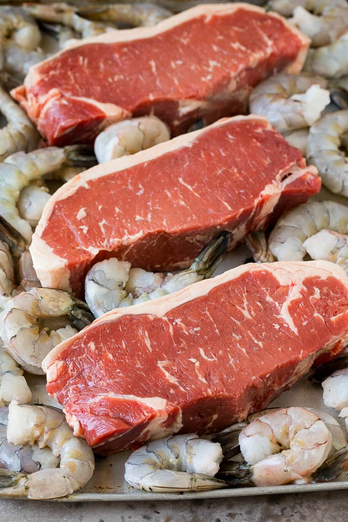 Surf and Turf Recipe | Seared Steak #steak #shrimp #keto #lowcarb #dinner #bajap Raw steaks and shrimp on a sheet pan.
