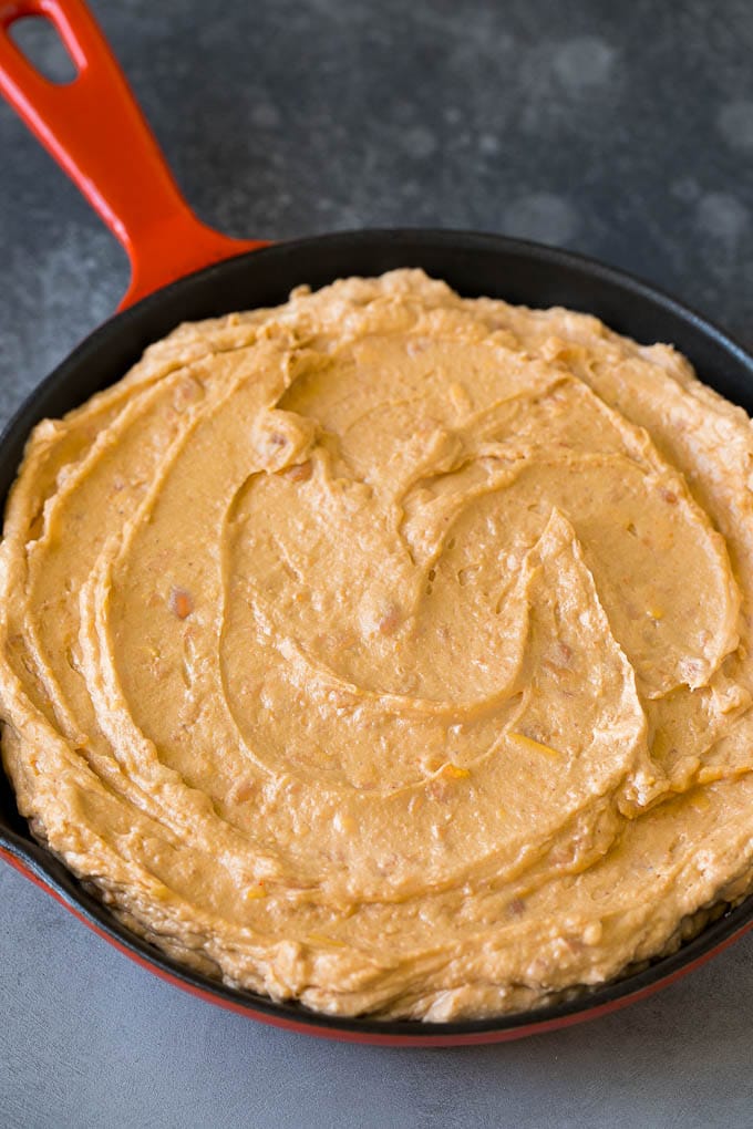 Bean Dip Recipe | Mexican Dip #dip #appetizer #mexicanfood #beans #cheese #bajap Refried frijoles mixed with cream cheese, sour cream and seasonings in a skillet.