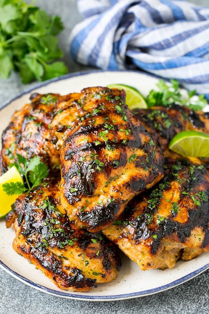 Grilled Chicken Thighs Recipe | Marinated Chicken Thighs #chicken #grilling #marinade #dinner #cilantro #lime #bajap Grilled chicken thighs with a garnish of cilantro and lime wedges.
