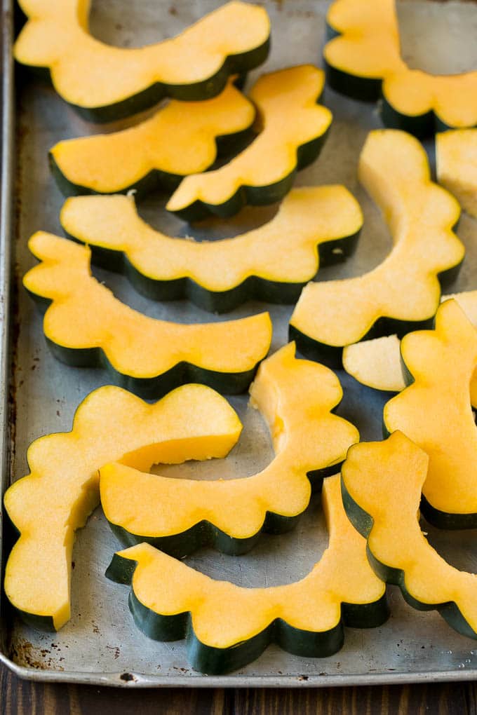 Roasted Acorn Squash | Acorn Squash Recipe #squash #winter #sidedish #dinner #bajap Sliced acorn squash on a sheet pan.