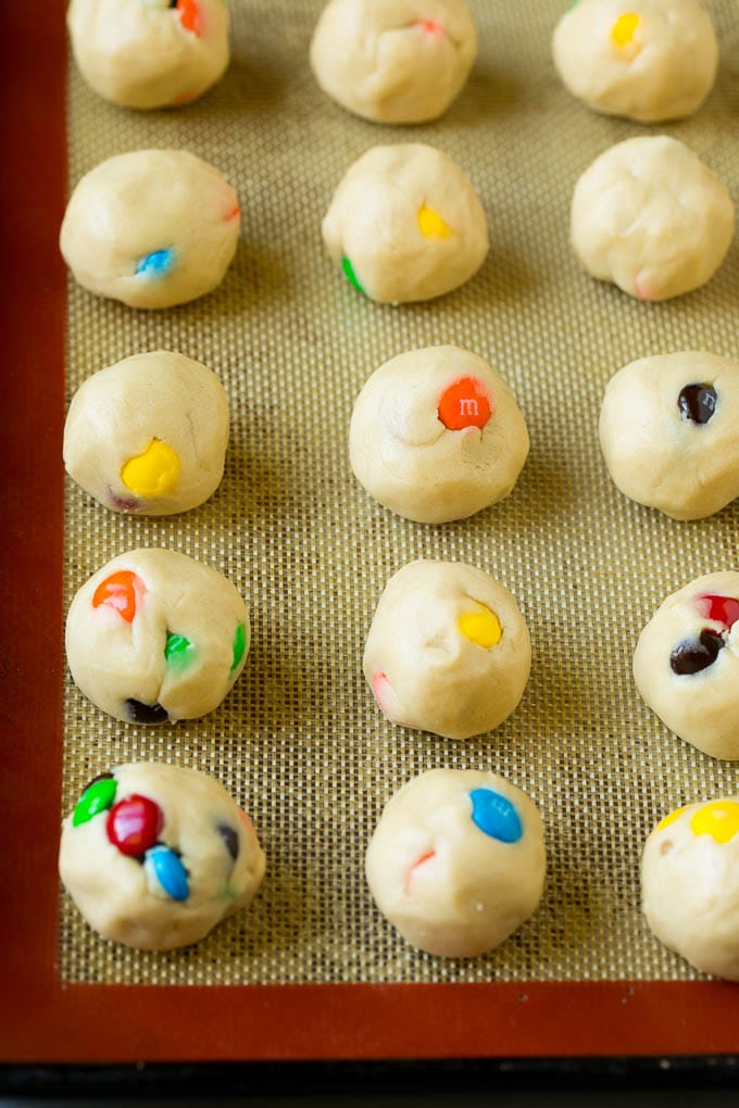 M&M Cookies Recipe #cookies #chocolate #baking #dessert #sweets #bajap Balls of cookie dough on a baking sheet.