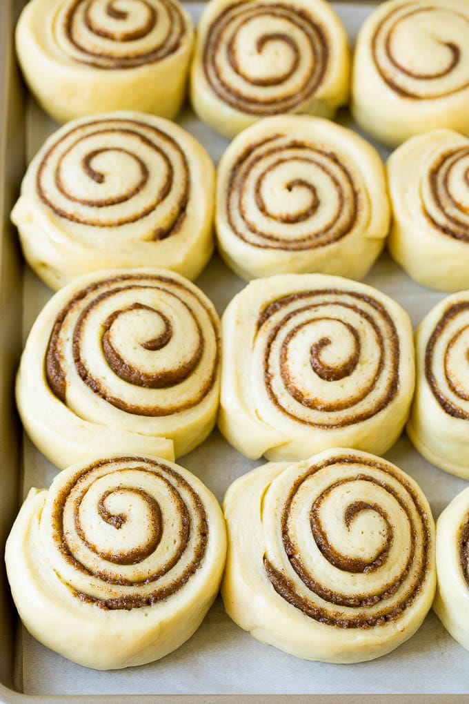 Cinnamon Rolls Recipe | Cinnamon Buns #cinnamon #rolls #pastry #breakfast #brunch #sweets #bajap #baking #bread Rolls of dough and filling rising on a sheet pan.