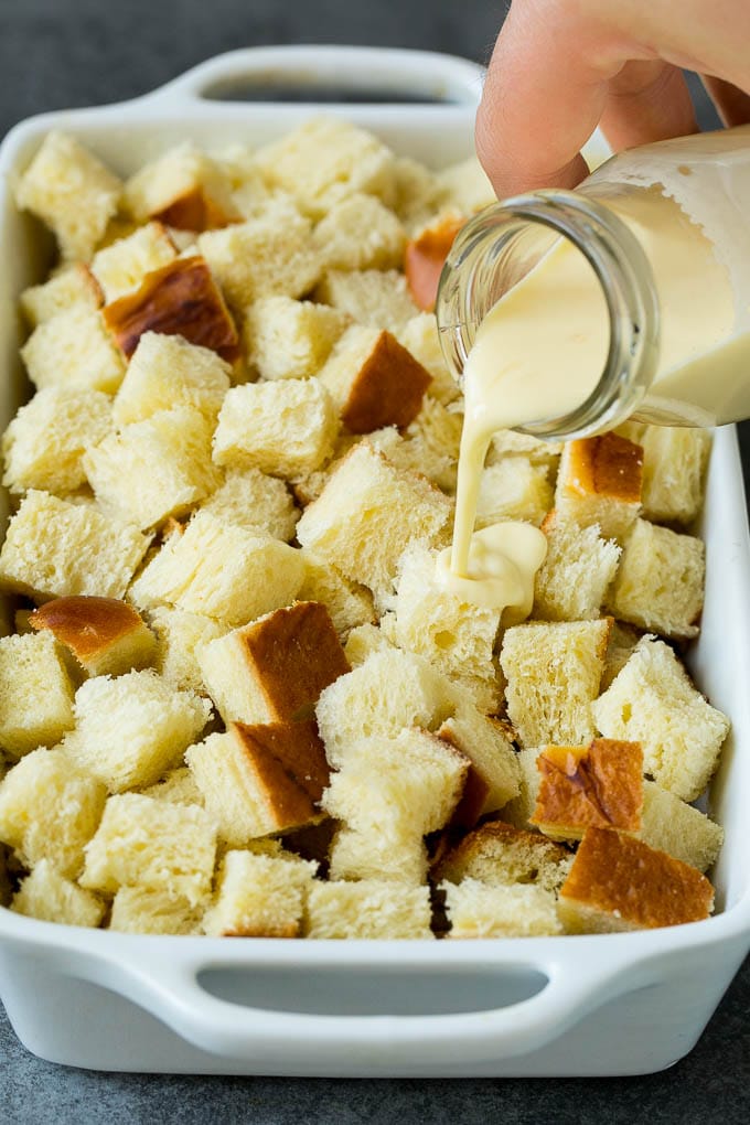 French Toast Casserole Recipe | French Toast Bake #frenchtoast #casserole #breakfast #brunch #bajap #bread A mixture of milk and eggs being poured over cubes of bread.