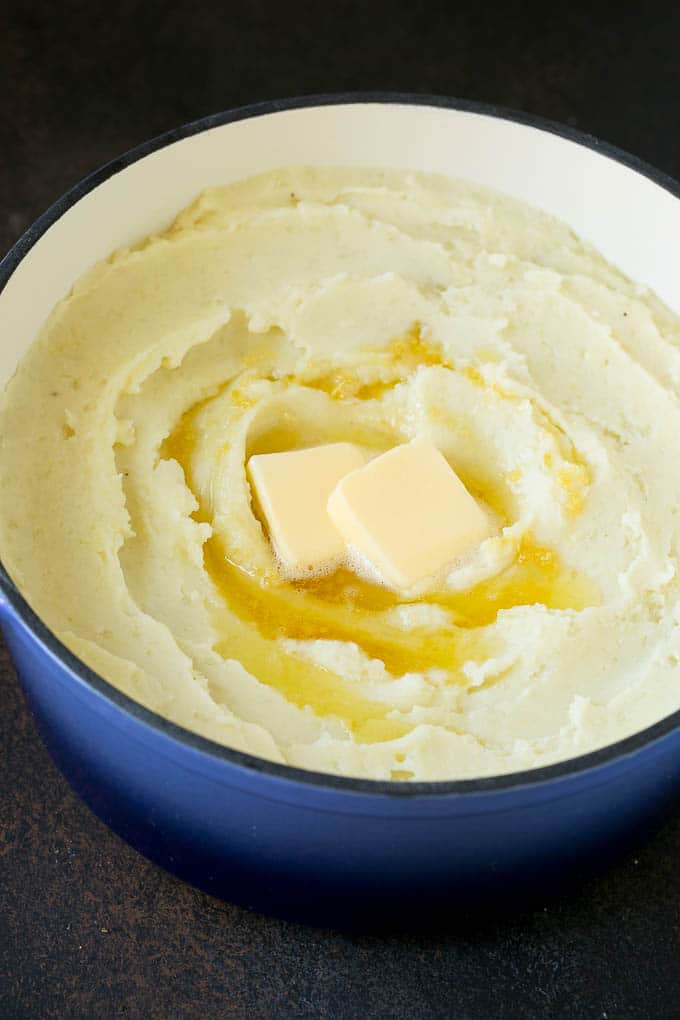 Garlic Mashed Potatoes Recipe #garlic #potatoes #mashedpotatoes #sidedish #dinner #thanksgiving #bajap Spuds with melted butter on top.