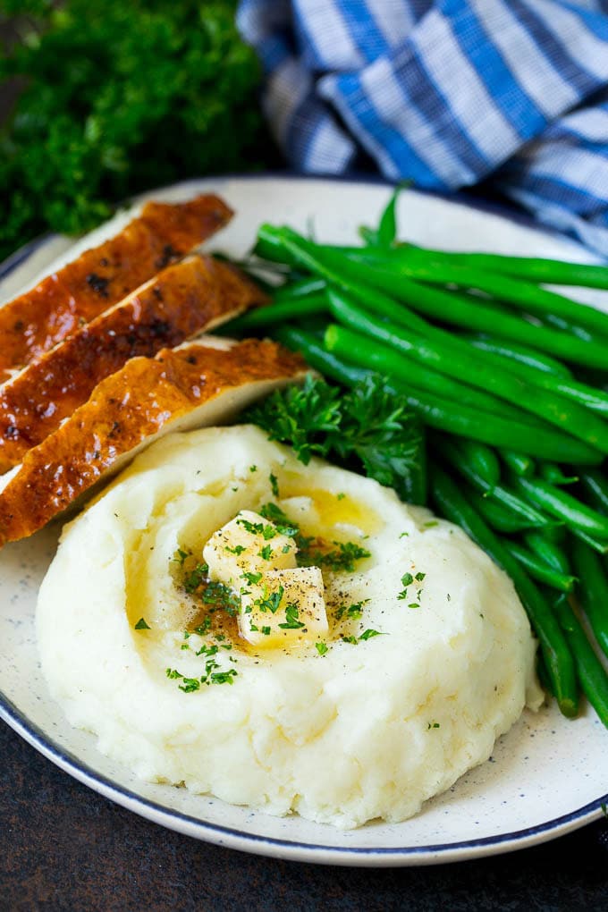 Garlic Mashed Potatoes Recipe #garlic #potatoes #mashedpotatoes #sidedish #dinner #thanksgiving #bajap A plate with garlic mashed potatoes, green beans and sliced turkey.