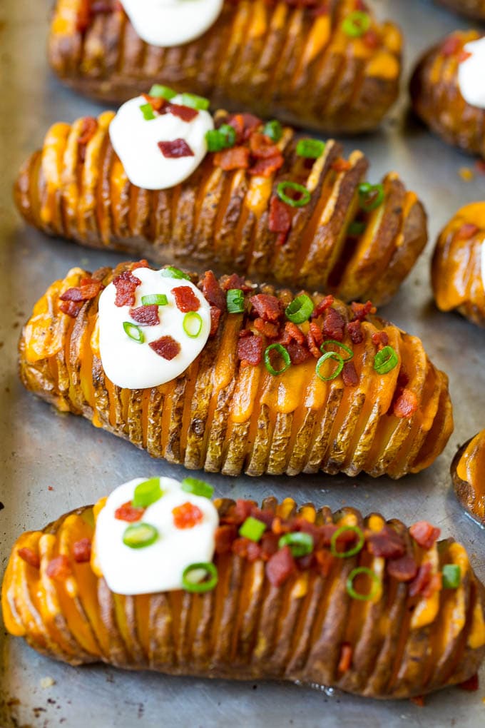 Hasselback Potatoes Recipe #potatoes #bacon #sidedish #cheese #dinner #bajap Hasselback potatoes filled with melted cheese, then topped with bacon, sour cream and green onions.