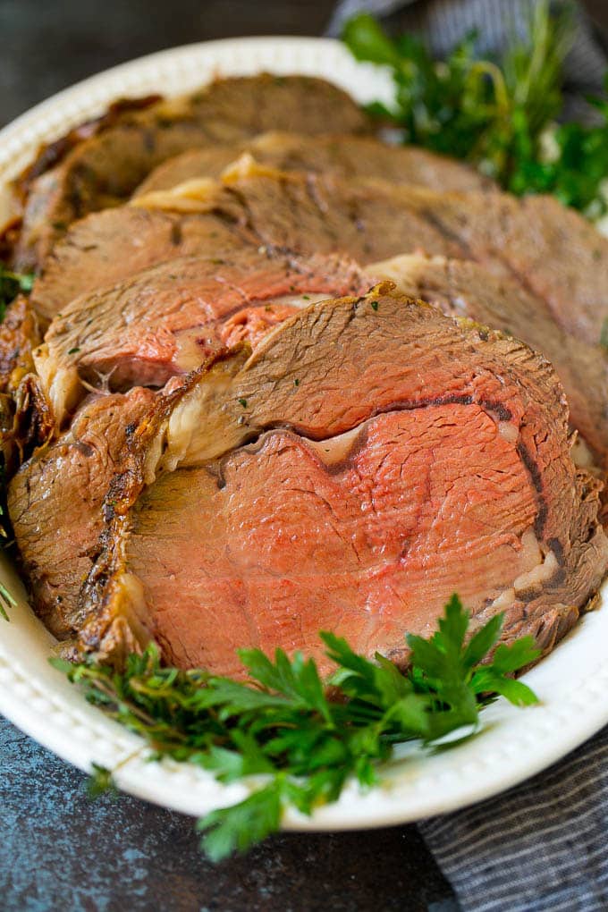 Prime Rib Recipe #primerib #beef #roast #dinner #thanksgiving #christmas #keto #lowcarb #bajap Sliced slow roasted prime beef on a serving platter.