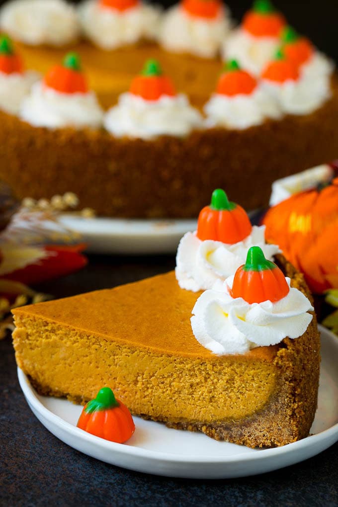 Pumpkin Pie Cheesecake Recipe | Pumpkin Cheesecake #cake #cheesecake #pumpkin #fall #thanksgiving #dessert #bajap A slice of pumpkin pie cheesecake garnished with whipped cream.