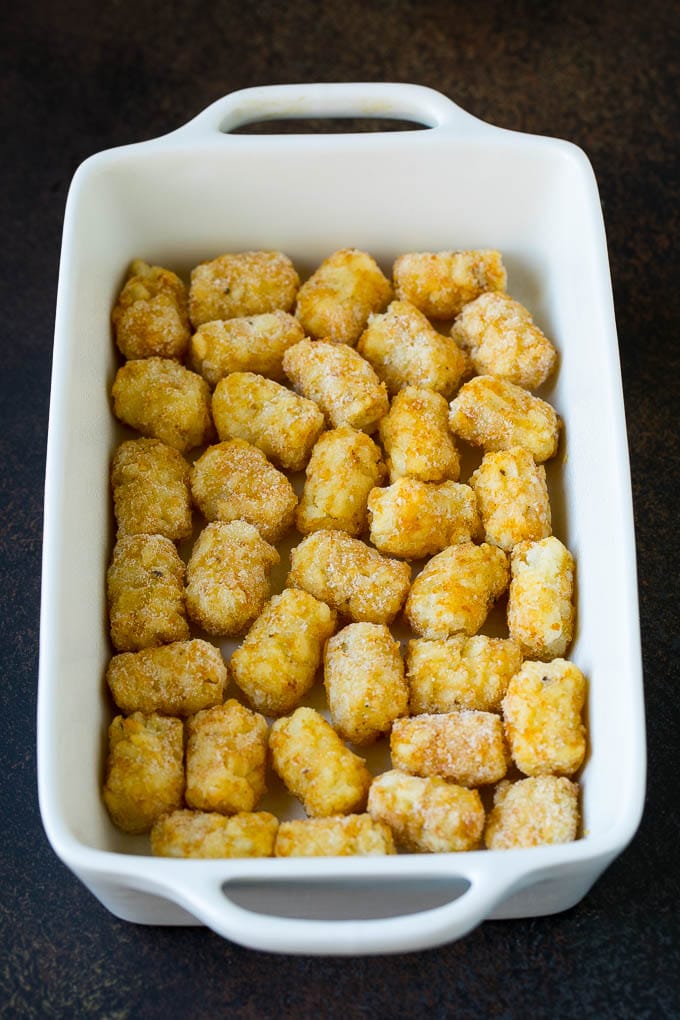 Sausage Egg Casserole Recipe | Egg Casserole #eggs #sausage #potato #cheese #casserole #breakfast #brunch #bajap Potato tots in a casserole dish.