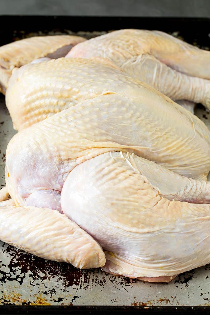 Spatchcock Turkey | Roasted Turkey | Thanksgiving Turkey #turkey #thanksgiving #dinner #fall #christmas #bajap A flattened whole turkey on a sheet pan.