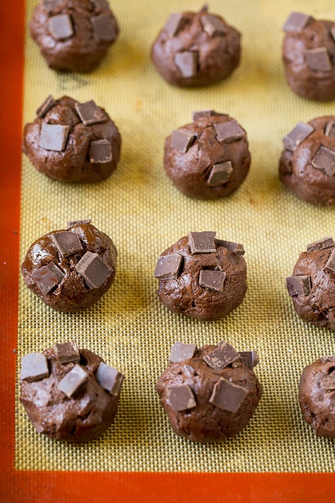 Brownie Cookies Recipe | Chocolate Cookies #cookies #brownies #chocolate #dessert #baking #bajap Balls of cookie dough with chocolate pieces pressed into the tops.