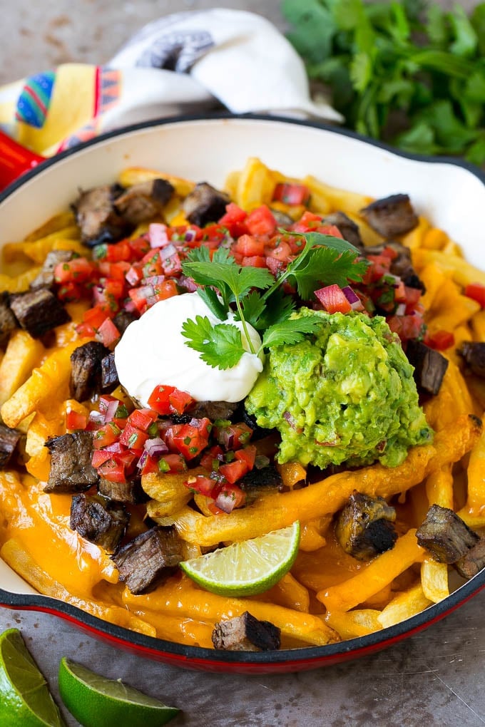 Carne Asada Fries Recipe | Steak Fries #fries #frenchfries #steak #salsa #avocado #cheese #dinner #appetizer #bajap Carne asada fries topped with melted cheese, steak, salsa and guacamole.