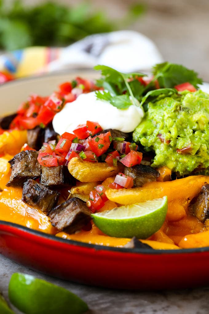 Carne Asada Fries Recipe | Steak Fries #fries #frenchfries #steak #salsa #avocado #cheese #dinner #appetizer #bajap Carne asada fries in a skillet topped with sour cream, pico de gallo and steak.