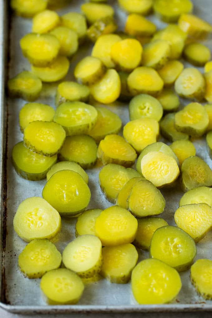 Fried Pickles Recipe #pickles #appetizer #snack #bajap Sliced dills on a sheet pan.