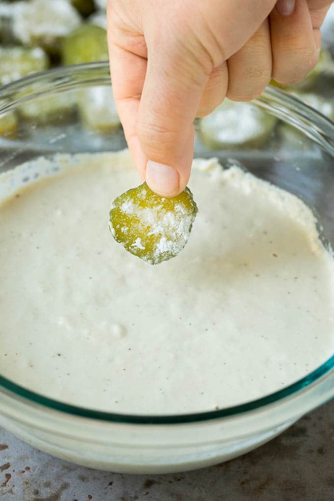 Fried Pickles Recipe #pickles #appetizer #snack #bajap A slice being dipped into a bowl of beer batter.