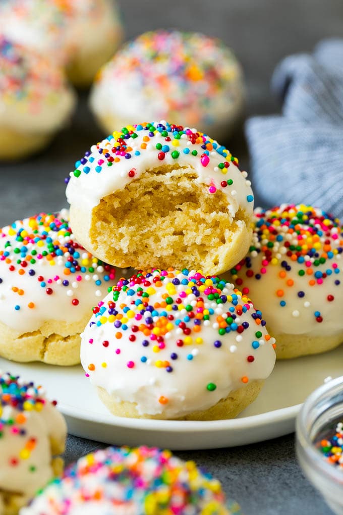 Italian Cookies Recipe | Almond Cookies #cookies #italianfood #frosting #sprinkles #baking #christmas #bajap A plate of Italian cookies with a bite taken out of one.