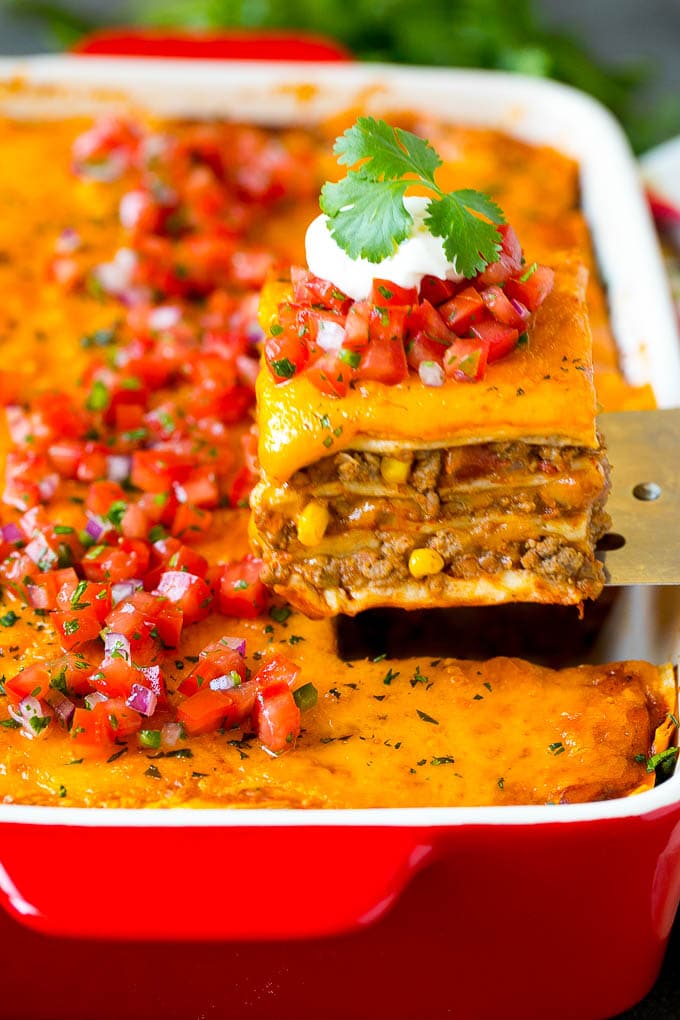 Mexican Lasagna Recipe | Mexican Casserole #mexican #lasagna #groundbeef #beans #dinner #cheese #bajap A spatula serving up a portion of Mexican lasagna.