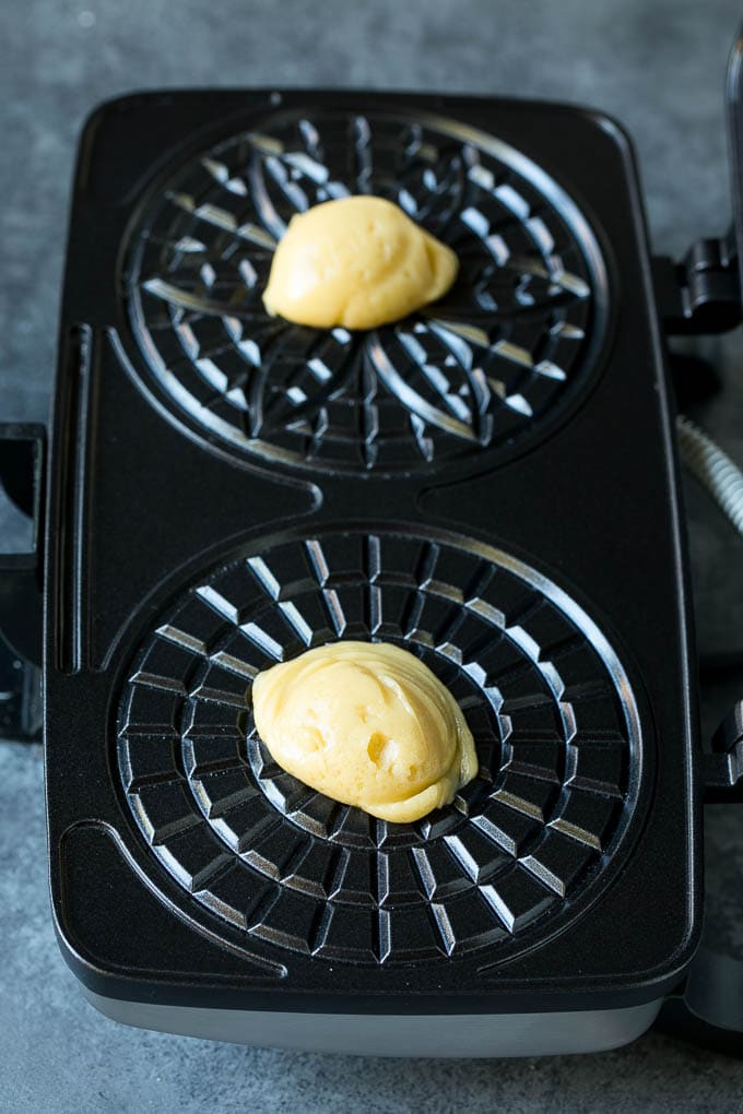 Pizzelle Cookies Recipe #cookies #baking #dessert #christmas #bajap Dollops of dough in a cookie iron.