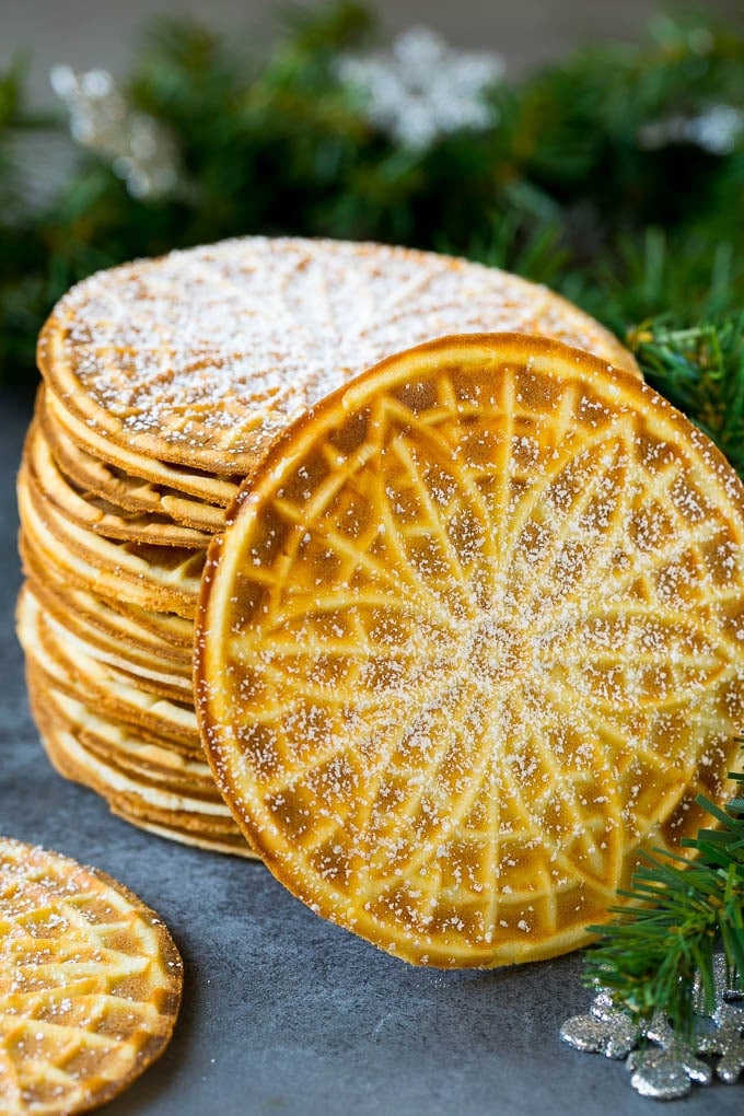 Pizzelle Cookies Recipe #cookies #baking #dessert #christmas #bajap A stack of pizzelle cookies dusted with powdered sugar.