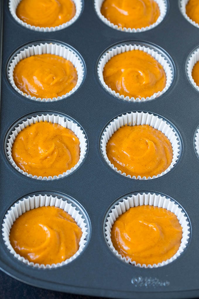 Pumpkin Cupcakes Recipe | Pumpkin Cake #cake #cupcakes #pumpkin #frosting #baking #fall #thanksgiving #bajap Batter inside paper cups in a muffin tin.